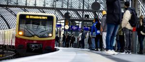 Reisende warten bei einem S-Bahn-Zug am Berliner Hauptbahnhof.