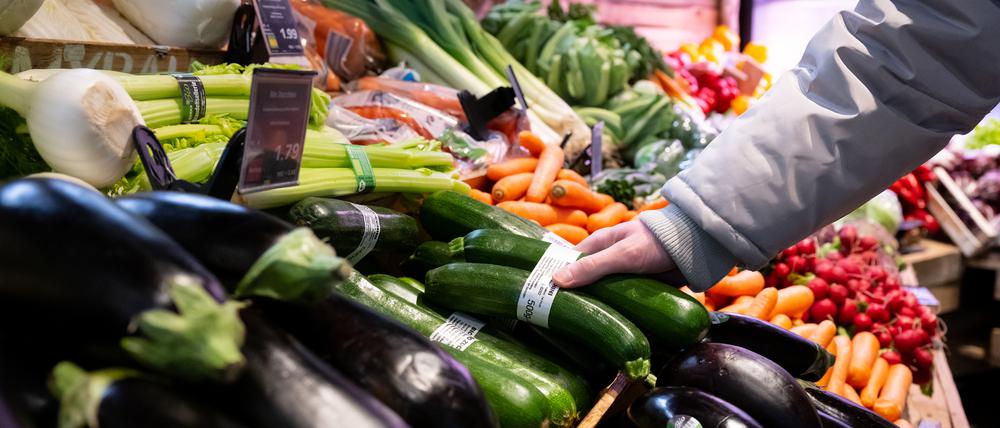 Ein Mann steht in einem Supermarkt an einer Auslage in der Obst und Gemüseabteilung. (Symbolbild)