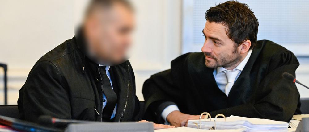 Der Angeklagte spricht im Verhandlungssaal mit seinem Anwalt.