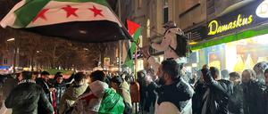 Syrer versammeln sich im Bezirk Neukölln mit Flaggen vor der Bäckerei Damaskus und feiern den Vormarsch der Rebellen auf Damaskus. 