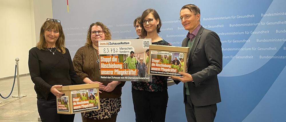 Karl Lauterbach nimmt eine Petition gegen die Abschiebung der zehn kolumbianischen Pflegekräfte entgegen.