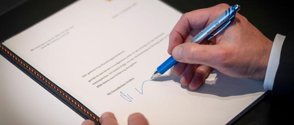 Dieses von der Bundesregierung zur Verfügung gestellte Foto zeigt Bundeskanzler Olaf Scholz (SPD) bei der Unterzeichnung des Antrags auf Vertrauen an die Bundestagspräsidentin in seinem Büro im Bundeskanzleramt.