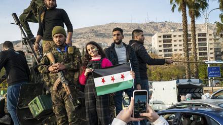 Vom Diktator befreit. Soldaten und Zivilisten mit der Flagge der syrischen Regimegegner.