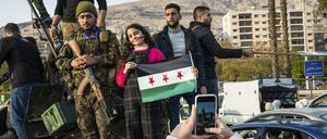 Vom Diktator befreit. Soldaten und Zivilisten mit der Flagge der syrischen Regimegegner.