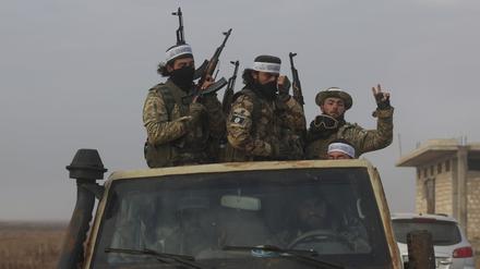 Syrische Oppositionskämpfer fahren auf einem Lastwagen durch Talhiya in der Region Idlib, Syrien. 
