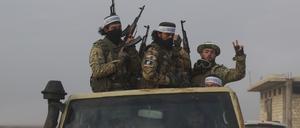 Syrische Oppositionskämpfer fahren auf einem Lastwagen durch Talhiya in der Region Idlib, Syrien. 