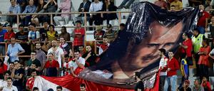 Syrische Fußball-Fans halten 2018, bei einem Spiel gegen Südkorea, ein Banner mit einem Bild von Baschar al-Assad in die Höhe.