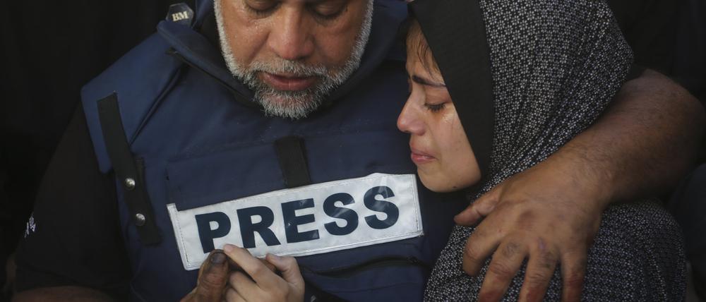Der Al-Dschasir-Journalist Wael al-Dahdu hält die Hand seines Sohns Hamza, der ebenfalls für den Nachrichtensender arbeitete und bei einem israelischen Luftangriff getötet wurde. 
