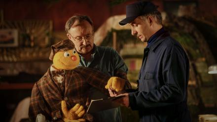 Spencer (l-r) und Jakob Sesam (Rainer Bock) bestätigen dem Lieferanten (Jan Böhmermann) gemeinsam die Lieferung alter „Hallo Spencer“-Sendebänder in einer Szene des Films „Hallo Spencer - Der Film“.