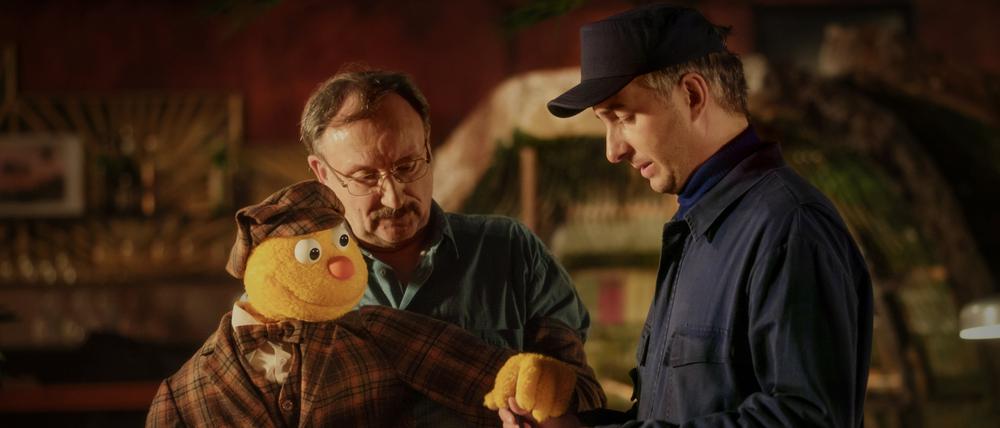 Spencer (l-r) und Jakob Sesam (Rainer Bock) bestätigen dem Lieferanten (Jan Böhmermann) gemeinsam die Lieferung alter „Hallo Spencer“-Sendebänder in einer Szene des Films „Hallo Spencer - Der Film“.