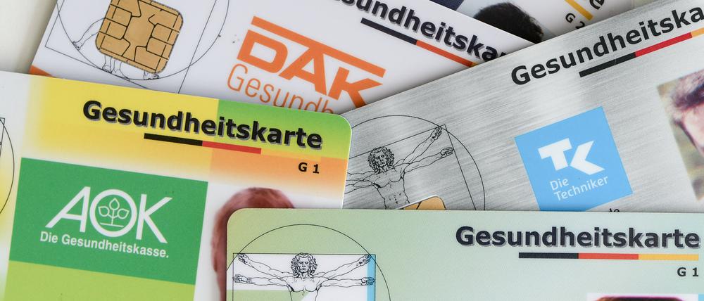 Gesundheitskarten verschiedener Krankenkassen liegen auf einem Tisch (Symbolbild).