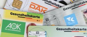 Gesundheitskarten verschiedener Krankenkassen liegen auf einem Tisch (Symbolbild).