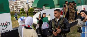 Noch Honeymoon: Bewohner der Stadt Latakia, aus der der gestürzte Diktator Assad stammt, setzen sich für Fotos mit Gewehren der HTS-Miliz in Szene. 