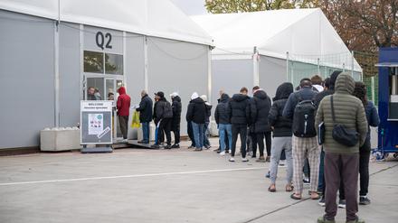 Am ehemaligen Flughafen Berlin-Tegel stehen Geflüchtete für eine Jobmesse an.