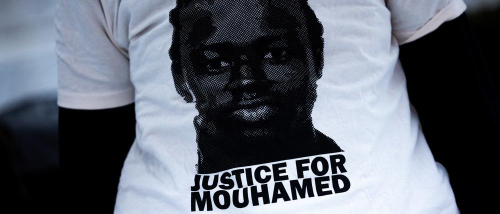 Eine Demonstrantin trägt ein T-Shirt mit der Aufschrift „Justice for Mouhamed“ vor dem Landgericht.