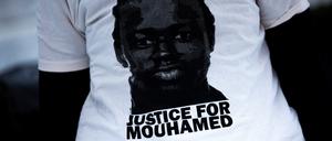 Eine Demonstrantin trägt ein T-Shirt mit der Aufschrift „Justice for Mouhamed“ vor dem Landgericht.