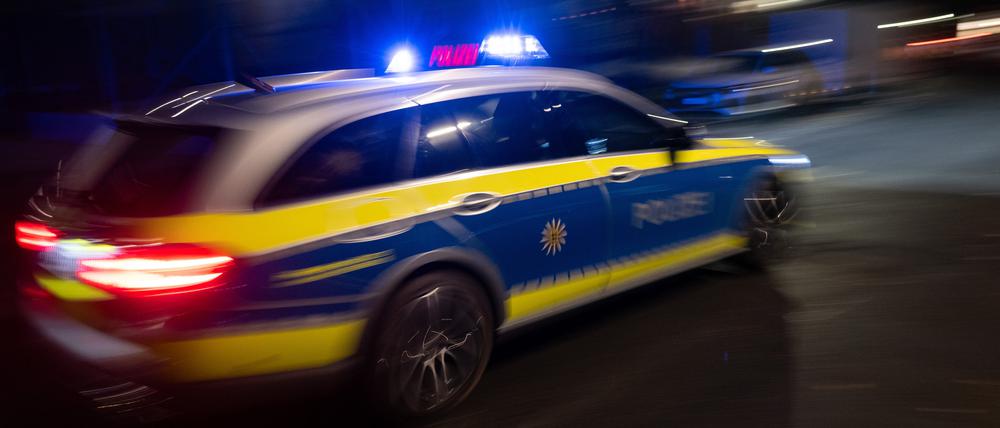 ILLUSTRATION - 30.11.2023, Baden-Württemberg, Stuttgart: Ein Polizeifahrzeug fährt mit Blaulicht an einem Gebäude vorbei (gestellte Szene, Langzeitblichtung mit Wischeffekt). (zu dpa: «Erneut Geldautomat in Berlin gesprengt») Foto: Marijan Murat/dpa +++ dpa-Bildfunk +++