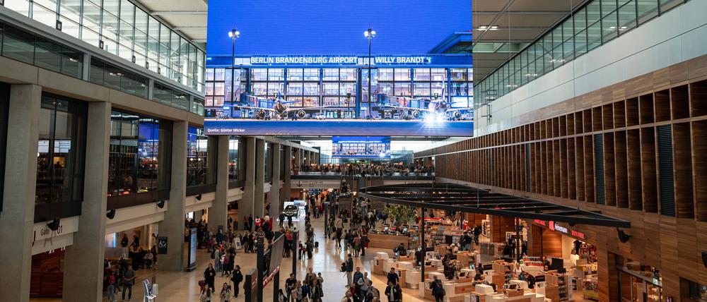 Eine Innenaufnahme zeigt Flugreisende in der Abflughalle des Terminal 1 am Flughafen Berlin-Brandenburg International BER Willy Brandt.
