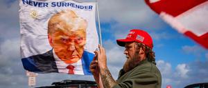 Ein Trump-Fan in Florida vor einer Flagge mit dem Konterfei des US-Präsidenten.