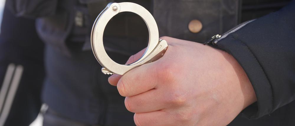 Ein Polizist hält Handschellen in der Hand