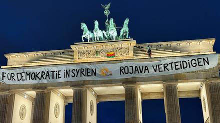 Activists of „RiseUp4Rojava“ , place a banner on top of the Brandenburg Gate to demand the end of attacks against the Democratic Autonomous Administration of North and East Syria (DAANES) also known as Rojava, in Berlin, Germany, December 16, 2024. The banner reads „For Democracy in Syria - Defend Rojava“.  REUTERS/Stefan Remter