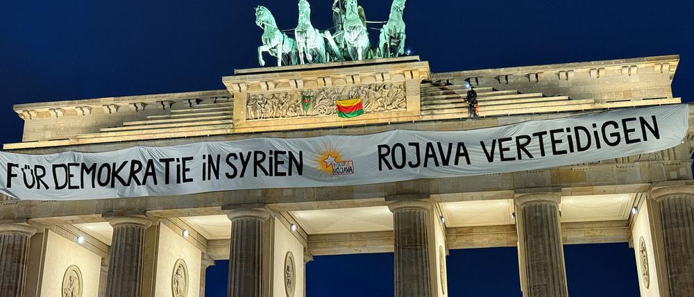 Activists of „RiseUp4Rojava“ , place a banner on top of the Brandenburg Gate to demand the end of attacks against the Democratic Autonomous Administration of North and East Syria (DAANES) also known as Rojava, in Berlin, Germany, December 16, 2024. The banner reads „For Democracy in Syria - Defend Rojava“. REUTERS/Stefan Remter