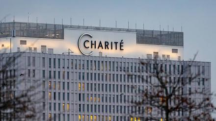 Der Schriftzug der Charité leuchtet über Berlin am großen Bettenhochhaus. 