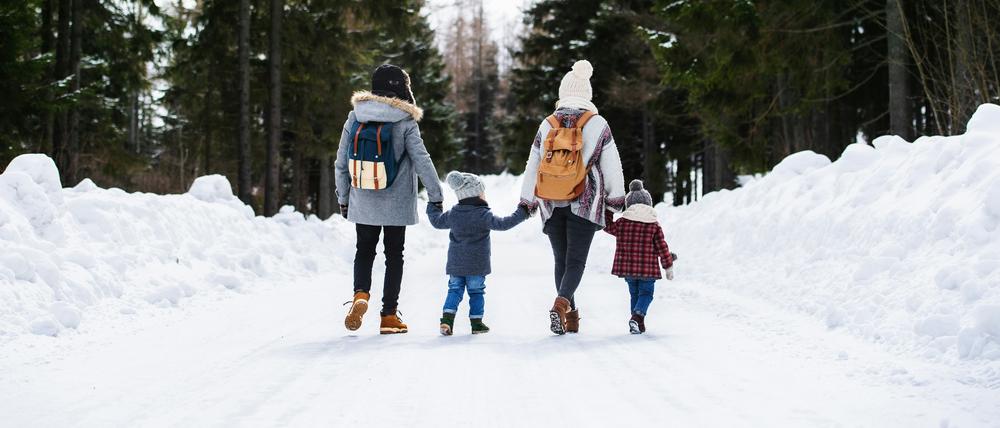 Eine Familie spaziert im Schnee.