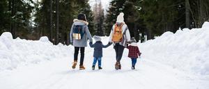 Eine Familie spaziert im Schnee.