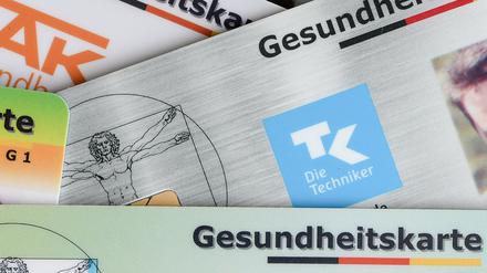 Gesundheitskarten verschiedener Krankenkassen liegen auf einem Tisch (Symbolbild).