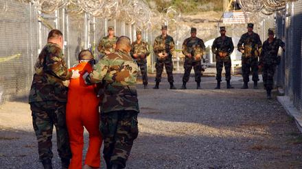 Die Richter des Obersten Gerichtshofs der USA stellten am 20. April 2004 in der ersten großen juristischen Prüfung des Krieges gegen den Terrorismus die Inhaftierung feindlicher Kämpfer durch die Regierung von US-Präsident George W. Bush in Guantánamo Bay, einer „gesetzlosen Enklave“, in Frage. Die Richter schienen tief gespalten in der Frage, ob Bush rechtlich befugt war, die unbefristete Inhaftierung von im Ausland gefangenen ausländischen Staatsbürgern anzuordnen und ihnen gleichzeitig das Recht zu verweigern, ihre Inhaftierung vor Gericht anzufechten. Militärpolizisten der US-Armee eskortieren einen Häftling zu seiner Zelle im Camp X-Ray auf dem Marinestützpunkt Guantanamo Bay, Kuba, während der Einweisung in die vorübergehende Hafteinrichtung, wie auf diesem Foto vom 11. Januar 2002 zu sehen ist.