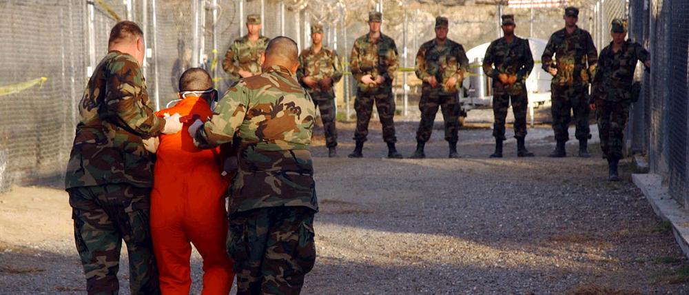 Die Richter des Obersten Gerichtshofs der USA stellten am 20. April 2004 in der ersten großen juristischen Prüfung des Krieges gegen den Terrorismus die Inhaftierung feindlicher Kämpfer durch die Regierung von US-Präsident George W. Bush in Guantánamo Bay, einer „gesetzlosen Enklave“, in Frage. Die Richter schienen tief gespalten in der Frage, ob Bush rechtlich befugt war, die unbefristete Inhaftierung von im Ausland gefangenen ausländischen Staatsbürgern anzuordnen und ihnen gleichzeitig das Recht zu verweigern, ihre Inhaftierung vor Gericht anzufechten. Militärpolizisten der US-Armee eskortieren einen Häftling zu seiner Zelle im Camp X-Ray auf dem Marinestützpunkt Guantanamo Bay, Kuba, während der Einweisung in die vorübergehende Hafteinrichtung, wie auf diesem Foto vom 11. Januar 2002 zu sehen ist.