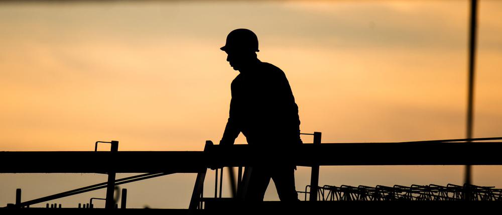 Ein Bauarbeiter in der Morgendämmerung. Laut Ifo-Beschäftigungsbarometer wollen viele Unternehmen Personal abbauen, in der Baubranche zeichnet sich jedoch keine größere Entlassungswelle ab.