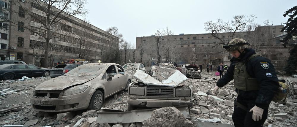 Ein Polizist geht an Autos vorbei, die nach einem russischen Raketenangriff in Saporischschja im Südosten der Ukraine von den Trümmern zerquetscht wurden. Mindestens drei Menschen sind bei dem Angriff Ende letzter Woche getötet und 14 Personen verletzt worden.