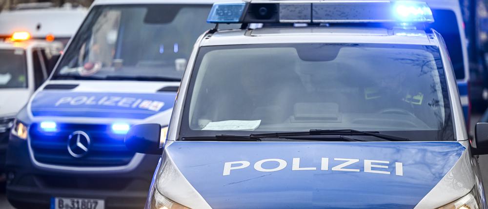 Polizeiautos mit eingeschalteten Scheinwerfern und Blaulicht. (Symbolbild)