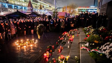Teilnehmer des Gedenkens zum 8. Jahrestag des Terroranschlags auf den Weihnachtsmarkt am Berliner Breitscheidplatz versammeln sich am Mahnmal «Goldener Riss». Am Abend des 19. Dezembers 2016 steuerte der islamistische Terrorist Anis Amri einen Lastwagen in die Besuchermenge des Weihnachtsmarktes. Durch den Terroranschlag verloren 13 Menschen ihr Leben.