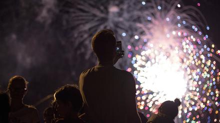Menschen betrachten ein Feuerwerk.