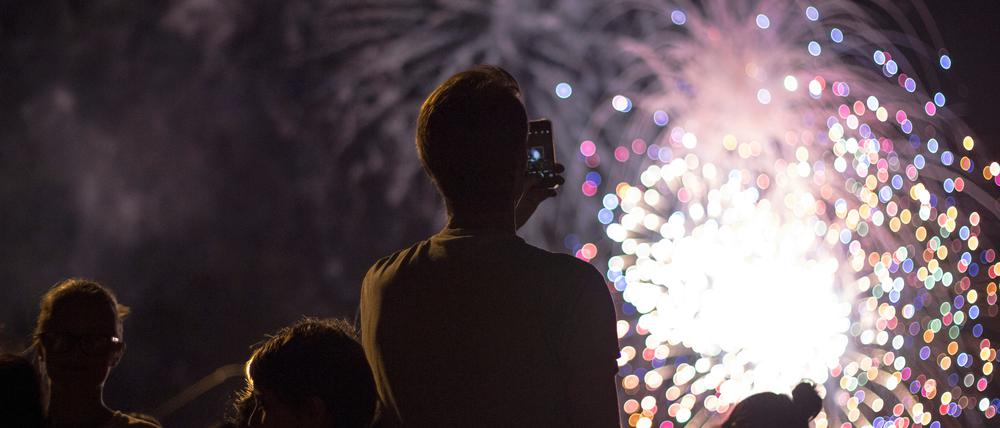 Menschen betrachten ein Feuerwerk.