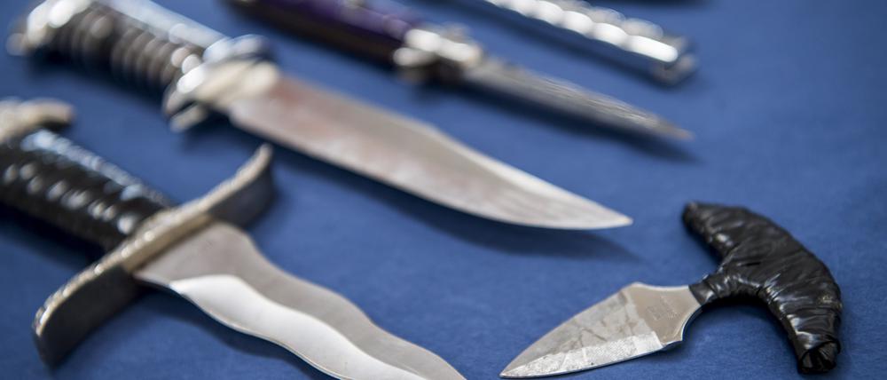 ARCHIV - 03.07.2018, Hamburg: Messer mit einer Klingenlänge über sechs Zentimeter und Faustmesser liegen bei einem Pressetermin der Bundespolizei auf einem Tisch. (zu dpa: «SPD-Fraktion fordert Waffenverbot im ÖPNV im Norden») Foto: Malte Christians/dpa +++ dpa-Bildfunk +++