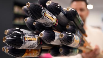 Ein Mitarbeiter hält im Showroom der Feuerwerksfirma Weco Silvesterraketen. 