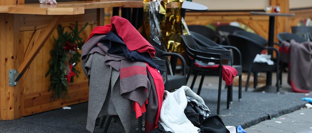 21.12.2024, Sachsen-Anhalt, Magdeburg: Eine Notfalldecke und andere Decken sind an einer Bude am Magdeburger Weihnachtsmarkt zu sehen. Am Vorabend war ein Autofahrer in eine Menschengruppe gefahren. Es gab Tote und Verletzte. Foto: Jan Woitas/dpa +++ dpa-Bildfunk +++
