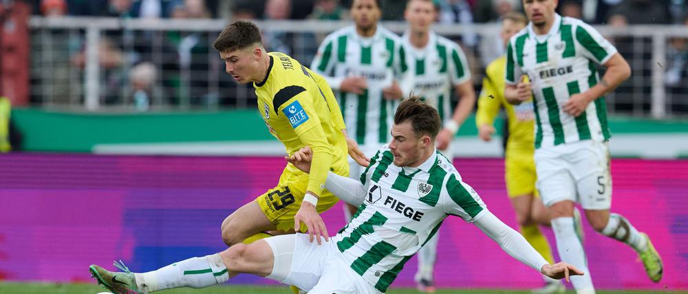 Münsters Niko Koulis verhindert eine Chance des Ulmers Semir Telalovic (l).