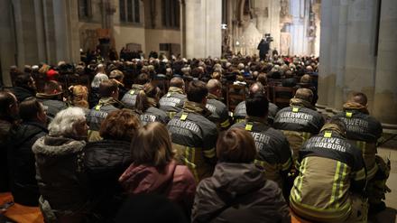 Feuerwehrleute nehmen am Gedenkgottesdienst teil.