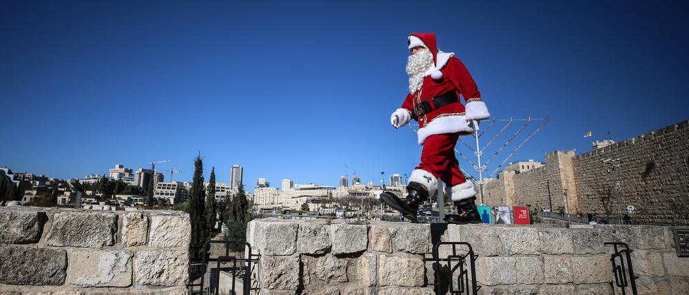 Der christliche Palästinenser Issa Kassissieh spielt auf der Mauer der Jerusalemer Altstadt den Weihnachtsmann. 