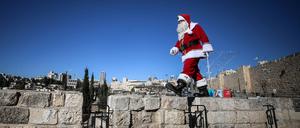 Der christliche Palästinenser Issa Kassissieh spielt auf der Mauer der Jerusalemer Altstadt den Weihnachtsmann. 