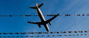 Ein Flugzeug fliegt am Flughafen in Hannover hinter Stacheldraht.