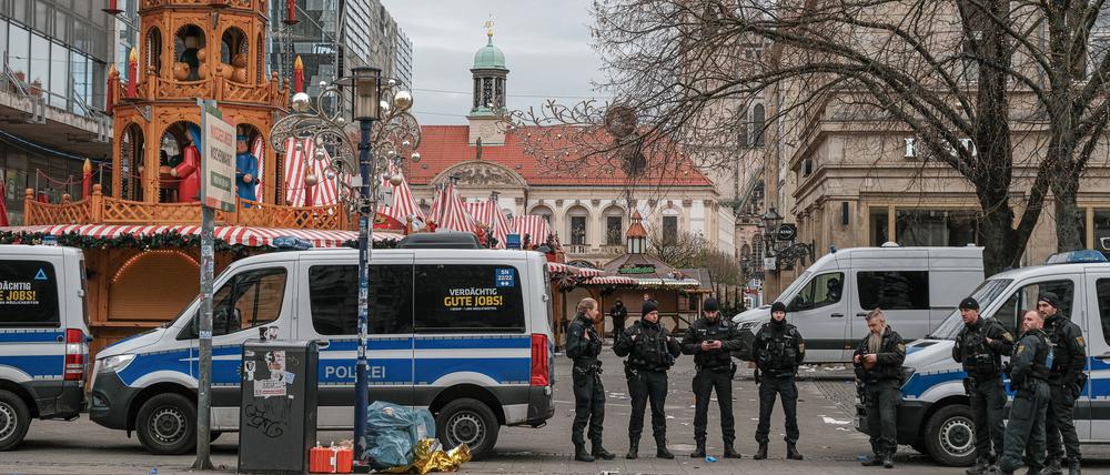 Polizisten bewachen nach dem Anschlag das Gelände des Magdeburger Weihnachtsmarkts.
