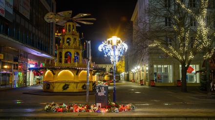 An der Zufahrt zum Magdeburger Weihnachtsmarkt stehen Kerzen und Blumen.