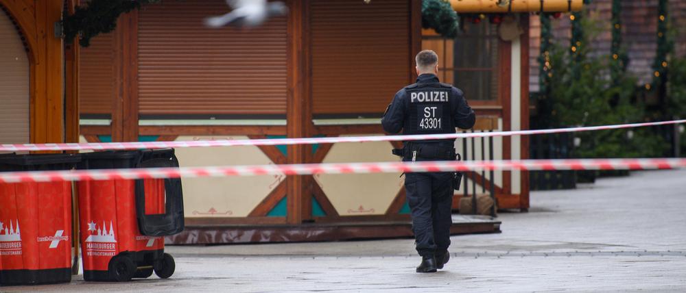 Ein Polizist geht am Sonntag über den geschlossenen Magdeburger Weihnachtsmarkt.
