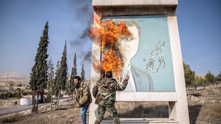 Syrische Rebellen verbrennen ein Bild des gestürzten Machthabers Assad.